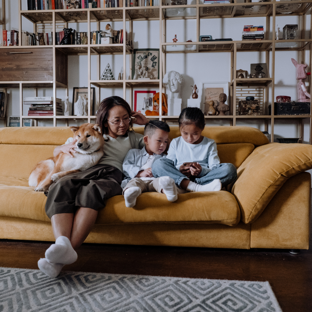 A mother with kids on a yellow sofa